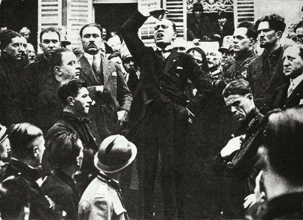 بنیتو موسولینی در ایتالیا سخنرانی می کند. دیکتاتور فاشیست آینده که به خاطر جذابیت و لفظ متقاعدکننده‌اش معروف است، در میان نارضایتی فزاینده در اوایل قرن بیستم به قدرت رسید
